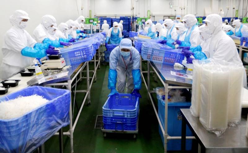 عمال في مصنع أغذية في ناراشينو في اليابان. 